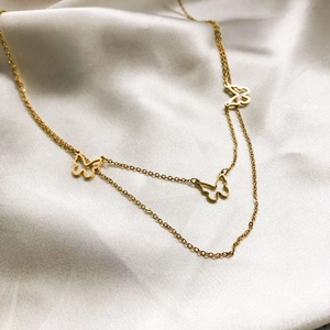 Macro view of gold-plated double-layer necklace with three hollow butterfly charms