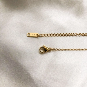 Detailed macro view of 18K gold butterfly necklace chain with lobster clasp and extender