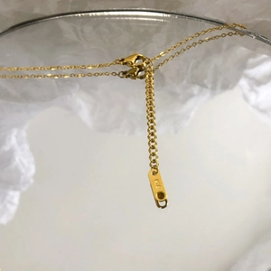 Macro shot of 18K gold necklace extension chain with lobster clasp and K18 engraving