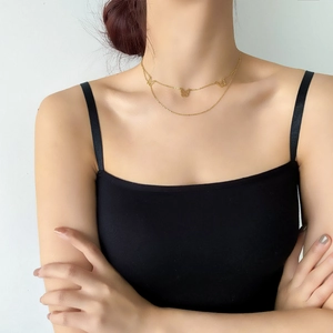 Detail of a golden double-layer necklace featuring three delicate hollow butterfly pendants