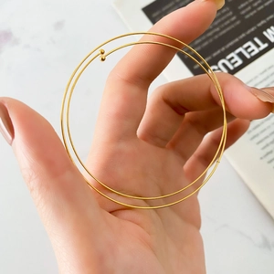 Close-up of minimalist gold double-layer spring bracelet with small ball ornaments