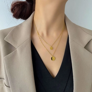 Close-up of double-layer gold necklace with circular pendants on professional model