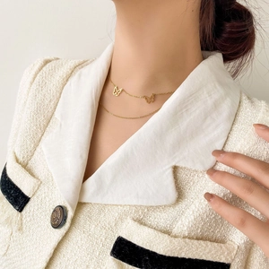 Close-up of double layer gold butterfly necklace worn by a model in elegant style