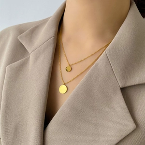 Close-up of minimalist double-layered gold necklace with two circular pendant charms on model