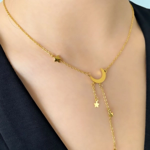 Détail du collier étoile et lune dorée avec chaîne délicate et pendentif à franges