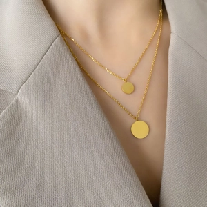 Double-layered gold round pendant necklace set for women on a stylish grey suit jacket