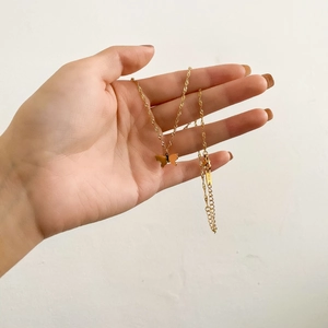 Gros plan du pendentif papillon en or 18 carats avec chaîne ondulée et fermoir mousqueton