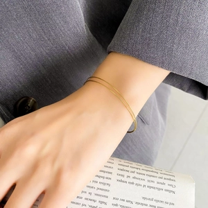 Close-up of minimalist double-loop gold spring bracelet worn on wrist for daily styling
