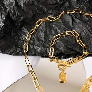 Parure de bijoux chaîne trombone dorée avec pendentif étoile à huit branches et gemme