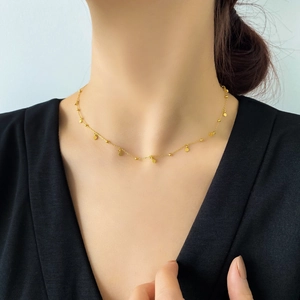 Close-up of minimalist 18k gold plated choker featuring delicate small round disc charms