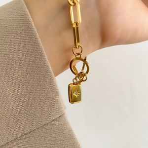 Détail du bracelet chaîne trombone dorée avec pendentif étoile et fermoir à bascule