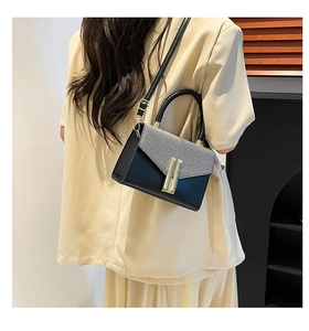 Detailed back view of a chic color-block crossbody bag with gold metal clasp on a model