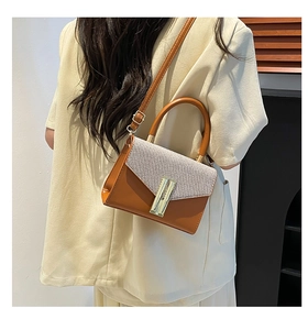 Detail of vintage square bag showing woven texture flap and golden metal buckle
