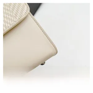 Dettaglio in tessuto intrecciato beige e pelle liscia con piedino in metallo per borsa
