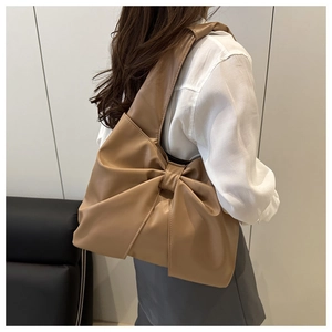 Macro shot of stylish khaki large bow shoulder bag in premium faux leather finish