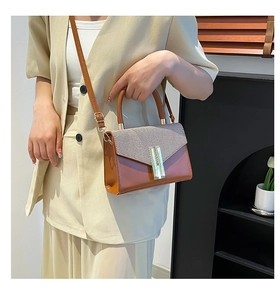 Chic handheld square bag with beige woven texture and brown leather styled on light suit