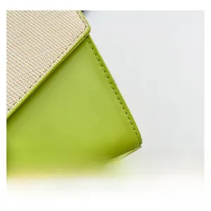 Close-up of bright green leather and beige woven fabric detail on a summer bag