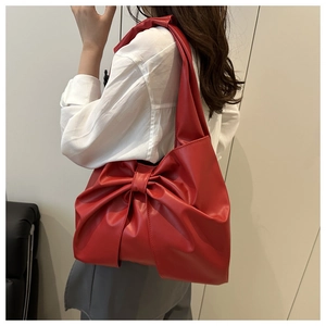 Stylish red denim tote bag with a large bow decoration and wide shoulder strap