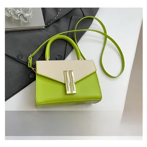 Detail of green leather handbag with beige woven flap and gold metal lock for office style