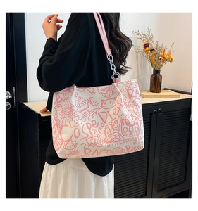 Detail of white graffiti canvas tote bag with pink leather chain straps on model