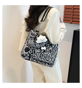 Detail of graffiti canvas tote with leather chain strap and cloud plush charm