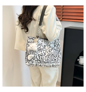 Detail of canvas tote bag with street graffiti, metal chain and plush cloud charm