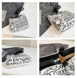 Detail view of graffiti canvas tote with leather handles and silver hardware zipper