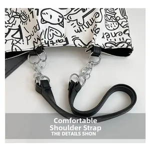 Detail of canvas tote with black graffiti cat patterns and leather metal chain strap