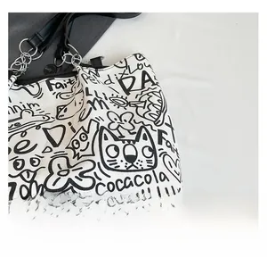 Detail of white canvas tote bag with black graffiti print and premium leather strap