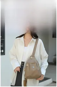 Model wearing a minimalist khaki oxford fabric chest bag in an urban street setting