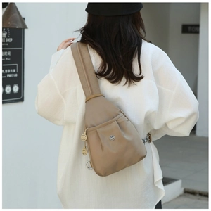 Rear view of khaki nylon mini chest bag with wide strap in a minimalist cafe setting