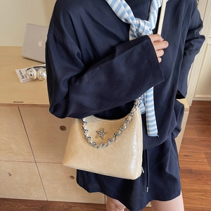 Sac à bandoulière chic en cuir verni beige avec étoile argentée et chaîne décorative