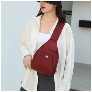 Outdoor shot of a woman wearing a dark red waterproof oxford fabric crossbody chest bag