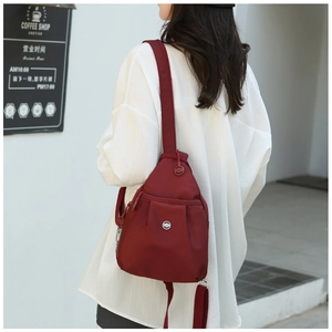 Detail shot of mini dark red oxford backpack with adjustable straps on a model