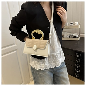 Detail of white leather shoulder bag with straw texture and artistic gold metal handle