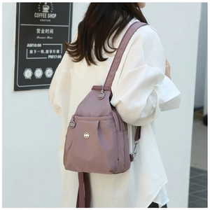 Detail view of mini Oxford fabric backpack showing soft pleats and metal ring zippers