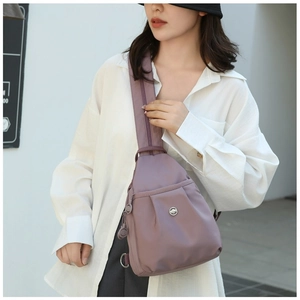 Detailed view of deep purple Oxford cloth crossbody bag with stylish pleated front pocket