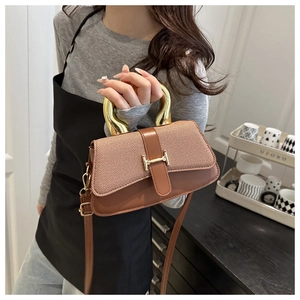 Detail of trendy brown square bag showing mixed fabric and leather textures with U-shaped handle