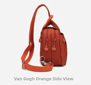 Detail view of Van Gogh Orange crossbody bag showing multi-layer zipper compartments