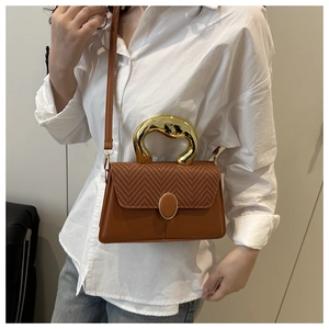 Brown crossbody bag with unique gold metal ring handle and woven texture detail