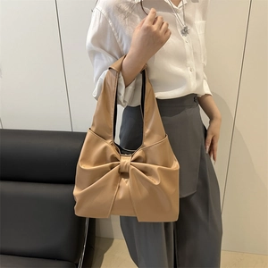 Minimalist camel tote bag with large bow detail and soft leather shoulder strap