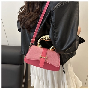 Detail of pink denim fabric bag with golden wavy handle and adjustable leather strap
