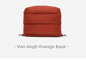 Detail view of the square base and metallic D-ring buckle of an orange nylon mini backpack