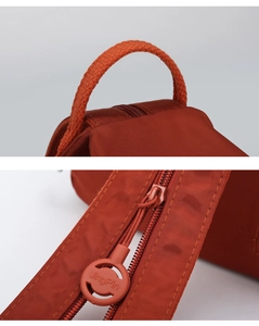 Close-up of durable oxford fabric texture and custom branded zipper on red mini backpack