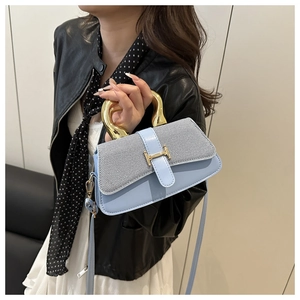 Detail view of light blue square bag featuring golden H-clasp and circular handle