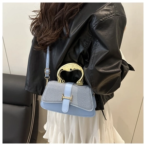 Detail of light blue crossbody bag with gold H-buckle and metallic top handle