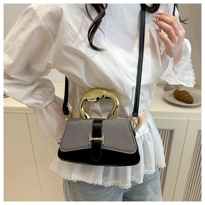 Detail of grey fabric bag with golden artistic handle and H-shaped decorative metal lock