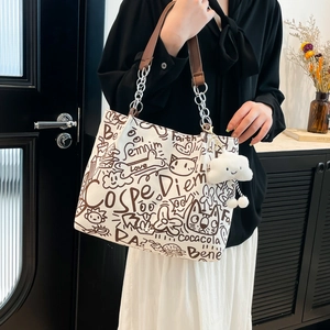 Graffiti canvas tote bag with chain strap and plush cloud charm for daily commute