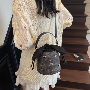 Denim bucket bag with silver butterfly charms and drawstring closure, cross-body style
