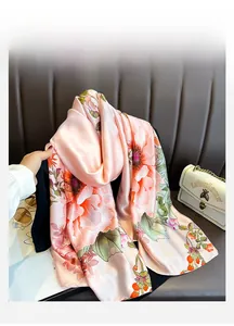 Detailed close-up of pink silk scarf featuring elegant floral patterns and a smooth texture